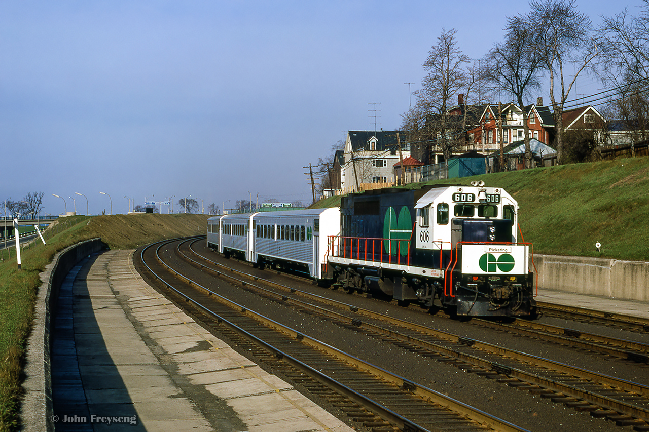 GO Transit GP40TC 606 brings up the rear of train 905, the 0700 departure from Pickering to Oakville, passing the old Exhibition station, located between Dufferin Street and Jameson Avenue.  This station, only consisting of two platforms, was opened in 1912 to serve the annual Canadian National Exhibition at the nearby Exhibition grounds, replacing an earlier station nearby.  It continued to see use until 1968, when the new Exhibition GO station was opened east of Dufferin Street, on the site of the original Exhibition station.  These platforms would see one more bit of service foir the 1979 CNE due to crowding at Exhibition GO, with this location being temporarily named "Dufferin Gates." Since then, the old platforms have remained abandoned and overgrown, with stairs to Dufferin Street fenced off.Scan and editing by Jacob Patterson.