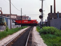 Looking south along the CN Newmarket Sub at Davenport diamond, a westbound train behind three big MLWs cuts through the scene.  This scene has changed dramatically in recent years with the elimination of the diamond <a href=https://www.railpictures.ca/?attachment_id=51598>in favour of an overpass (Eric Fallas shot here)</a> for the Metrolinx-owned portion of the Newmarket, carrying GO Transit and VIA Rail trains over CPKC's North Toronto Sub.

<br><br><i>Scan and editing by Jacob Patterson.</i>