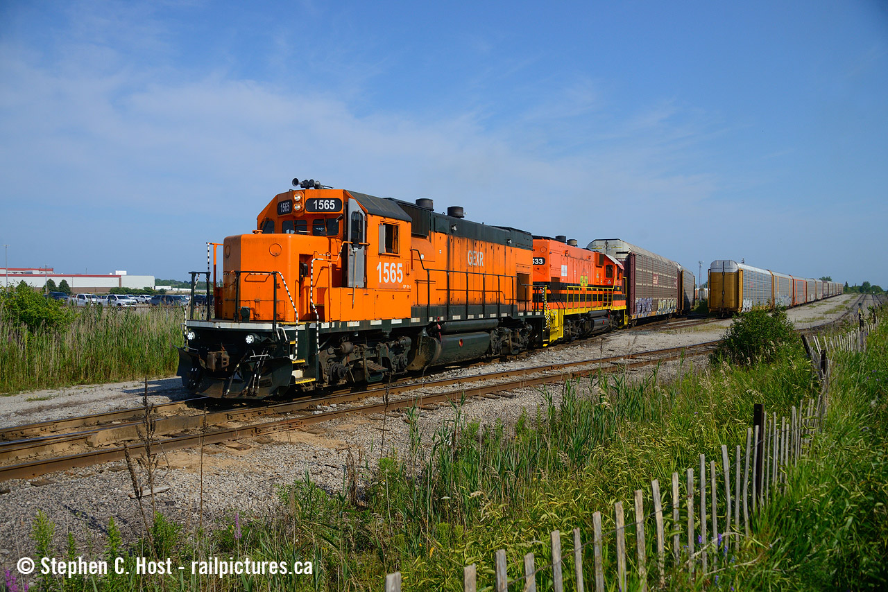 When these locomotives arrived, they weren't the first GP15's to be used in Canada by a Canadian outfit, VIP in Sarnia had a GP15-1 on lease for a few months a few years ago around 2020/2021. The GP15's are coming to shortlines throughout North America and they are killing a lot of first generation EMD and Alco products as UP is basically retiring their GP15-1 fleet, and they are being sold through various dealers or lease outfits. The GP15 was built as a GP9 replacement in the late 70's / early 80's and it seems it took 40 years for this to happen for real :)
These two are not from the UP though, they are former Conrail GP15-1's which went through LTEX eventually to the G&W Fold. And that orange paint? It's just one of the many LTEX paint schemes they have for lessors to choose from. This unit was scheduled to be painted in North Bay, but it missed the paint window when it was sent to the ONR, so after whatever repairs were made it was sent back to Oshawa be pressed into service. Thank the Lord, cause this orange sure is different.
Pictured is the Rail Synergy Oshawa job pulling out of the loading racks with a cut of cars for the CNR or CPRKC in Oshawa. They usually do two to three runs from here up the hill (heavy grades mean they can only take so much) then down to their respective yards. After finishing the autoracks, they head over to do the frames in the late afternoon, or so I am told. Do note while taking this photo the CPKC was in town lifting loaded autoracks from their yard - the G&W Boys would essentially follow CPKC across the bridge once they cleared to reverse into the depths of the oshawa yard tracks. It's great to see activity in Oshawa again after so many years. I'm looking forward to driving through again and dropping by to see what's going on - the Kingston sub is also very busy with tonnes of action - I'd get about 4-5 movements in an hour before leaving town.