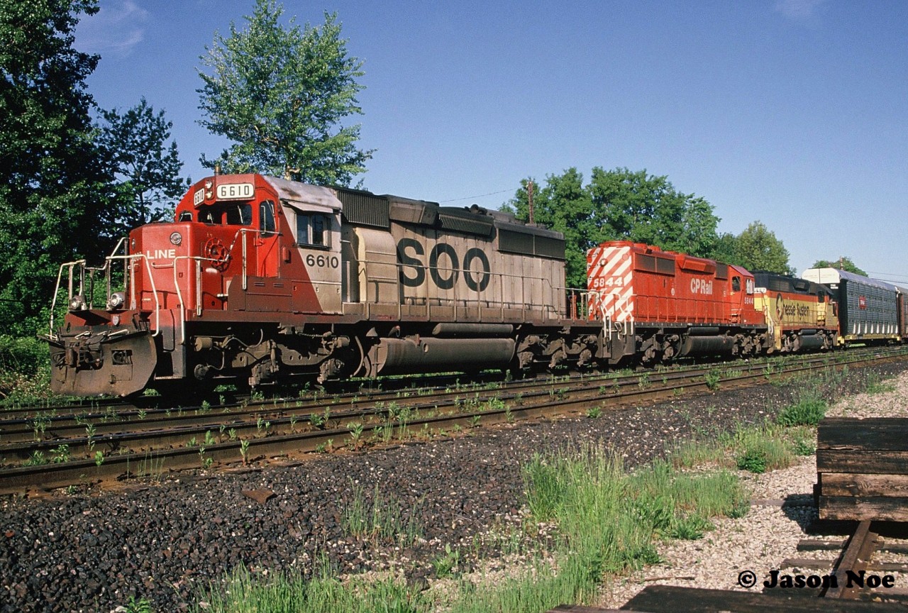 During an early June morning, an eastbound CP train is viewed waiting for a fresh crew at Quebec Street Yard in London, Ontario. The consist included; SOO Line SD40-2 6610, SD40-2 5844 and CSXT GP40 6562. The former Chessie unit was heading to AMF in Montreal, Quebec where it eventually would become HATX 401. And ironically by the fall of 1994 was immediately leased to CP. At the time, the railway had a large group of Helm Financial Corporation units leased as part of their rapidly expanding mid-90’s lease fleet.