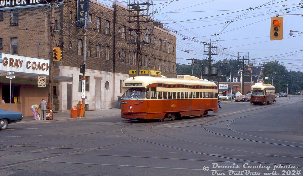 TTC PCC 4744 in "subway red" paint (A13-class, built by Pullman in 1947 for Birmingham, Alabama) turns westbound onto The Queensway off Roncesvalles on a Dundas short-turn, returning to nearby Roncesvalles Carhouse after morning rush hour. TTC 4653 (A11-class, built by Pullman in 1946 for Cleveland) follows behind, another Dundas car returning to the carhouse. Both are passing the old Edgewater Inn hotel and the Gray Coach terminal in Sunnyside.

Dennis Cowley photo, Dan Dell'Unto collection slide.