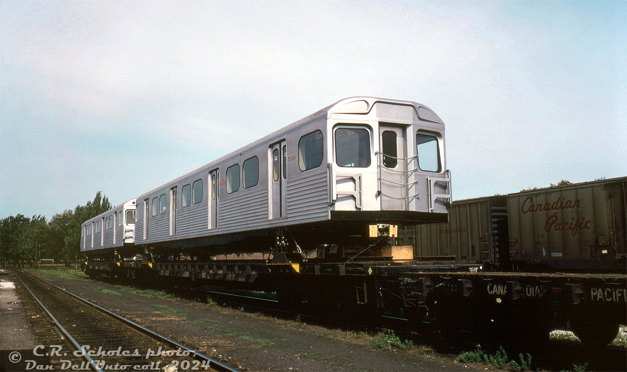 Brand new TTC H2 subway cars 5506 and 5507 sit on CP 313000-series flatcars (cut down heavyweight sleepers specifically for transporting new subway cars) at CP's West Toronto Yard near the erecting shop (backshop), awaiting the chance to go inside to get their new Dofasco trucks installed before delivery.

The H2 subway carbodies were built by Hawker Siddeley Canada at their Can-Car plant in Thunder Bay, Ontario, and shipped to Toronto via CP by rail. As per information in an old UCRS newsletter, the TTC wanted the cars delivered as "ready to roll" units, but the trucks (made by Dofasco down in Hamilton) could not be mated to the bodies at Greenwood Shops like the previous H1 order had. Instead, HSC leased space in CP's West Toronto erecting shop building where they would install the trucks underneath the cars one truck at a time using the shop's overhead crane. The car would then be interchange with CN at Parkdale Yard for final delivery to the TTC's Greenwood Yard. The Dofasco trucks would be shipped to West Toronto from Hamilton by truck for final installation.

The 76-car (5500-5576) H2 subway car deliveries continued in this fashion from May to November 1971. The new 76-car order was slow in entering service, as they were purchased as expansion units for the North Yonge subway extension (Eglinton to Finch) and not needed until the extensions opened in 1973 (to York Mills) and 1974 (to Finch). The cars would serve the TTC until replacement by new Bombardier T1 subway cars in the early 2000's.

C.R. Scholes photo, Dan Dell'Unto collection slide.