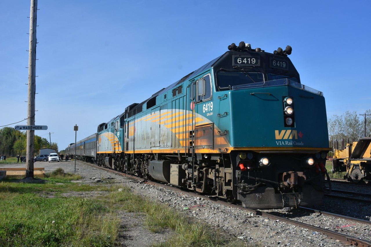 VIA 693 The Hudson Bay is making a scheduled station stop at Wabowden, MB Mile 136.4 HBR Wekusko Sub. on this beautiful September 18, 2024 morning. Supplies are off loaded, passengers get a chance to stretch their legs, and, VIA performs an unscheduled crew change.
Radio troubles in what was lead unit VIA 6433 has the train running 6+ hours late at Wabowden due to overnight switching moves to reverse the two locomotives putting VIA 6419 in the lead. The new crew was trucked out in the white van to the remote location to take over the throttle. 
All part of the fun and adventure of riding this iconic train to Churchill. :-)