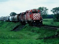 An eastbound CP train is viewed approaching the Komoka (Melrose) diamond crossing on the Windsor Subdivision, with the CN Strathroy Subdivision, situated west of London, Ontario. The consist included GP38-2 3030 and GP35 5012. At the time, the entire fleet of CP GP35’s was assigned to Western Canada and one straying this far east was very un-common. In August 1996 GP35 5012 was released from CP’s Weston Shops after conversion to control cab-daughter slug 1125. It was mated with GP38-2 ‘mother’ 3035 and assigned to Winnipeg. It was ultimately retired in October 2012.