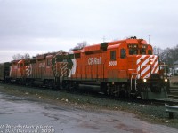 There's catches, there's "catches", and then there's CATCHES(!!!): both CP Rail GP30's, 5000 and 5001, set up elephant style, leading an eastbound freight together on a gloomy day at Galt.
<br><br>
In their early days the two CP GP30's (the only Canadian-built GP30 units at that) could often be found paired together, but by the 70's both were mixed in general freight service with CP's large fleet of 4- and 6-motor units, and it became somewhat harder to catch the duo working the same train. But apparently the stars aligned on this day, and both GP30's must have been at the same shop at the same time for some power planner or shop foreman to line up both together for a freight, elephant style, with a successor GP35 (5008) to boot. The occasion was not lost on Bill, who made sure to note "LOOK AT POWER!!" on the slide mount.
<br><br>
It appears someone at Toronto Yard may have <a href=http://www.railpictures.ca/?attachment_id=41079><b>had a thing for pairing them</b></a>. Later on in the 80's when a bunch of the GP30 and GP35 units were reassigned out west in BC, there were a few instances of both running together with other units on local freights. Both were retired in the 90's and disposed of, with one being donated to a <a href=http://www.railpictures.ca/?attachment_id=10246><b>museum</b></a> and the other ending up as a lease unit at a US grain elevator.
<br><br>
An interesting note here is 5000 had been repainted in relatively fresh 8" action red paint with large multimark (same paint as 5008 trailing), while 5001 retains its mid-70's "Ogden multi" paint with 5" stripes and small multimark. Both GP30's were still DRF (Diesel Road Freight) units, (converted to DRS (Diesel Road Switcher) next year in June 1980), but 5000 had been modified with smaller standard-sized EMD window glass in its middle front windows, while 5001 retains its wider as-built GP30 center windows (modified later).
<br><br>
<i>Bill McArthur photo, Dan Dell'Unto collection slide.</i>
