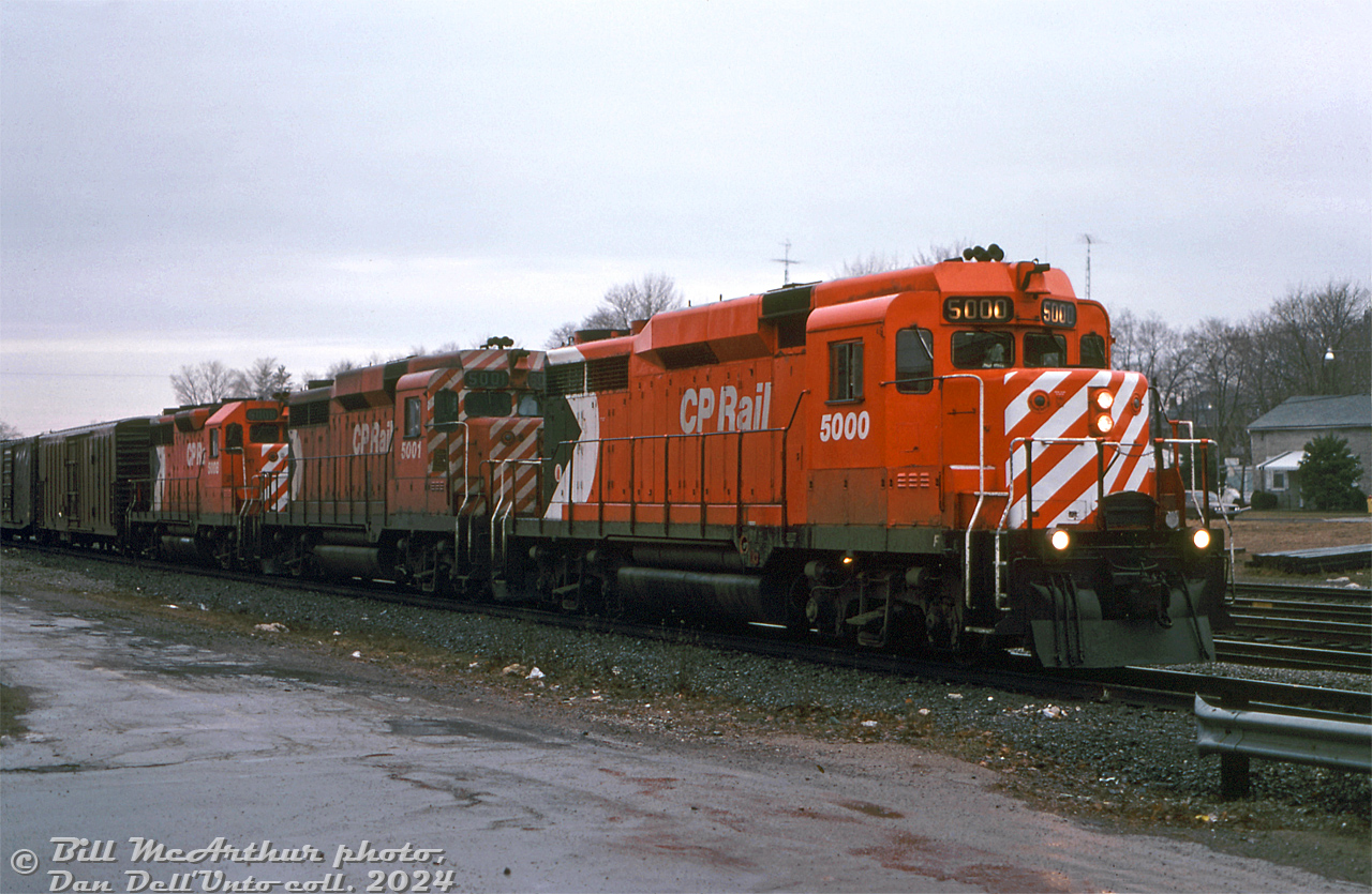 There's catches, there's "catches", and then there's CATCHES(!!!): both CP Rail GP30's, 5000 and 5001, set up elephant style, leading an eastbound freight together on a gloomy day at Galt.

In their early days the two CP GP30's (the only Canadian-built GP30 units at that) could often be found paired together, but by the 70's both were mixed in general freight service with CP's large fleet of 4- and 6-motor units, and it became somewhat harder to catch the duo working the same train. But apparently the stars aligned on this day, and both GP30's must have been at the same shop at the same time for some power planner or shop foreman to line up both together for a freight, elephant style, with a successor GP35 (5008) to boot. The occasion was not lost on Bill, who made sure to note "LOOK AT POWER!!" on the slide mount.

It appears someone at Toronto Yard may have had a thing for pairing them. Later on in the 80's when a bunch of the GP30 and GP35 units were reassigned out west in BC, there were a few instances of both running together with other units on local freights. Both were retired in the 90's and disposed of, with one being donated to a museum and the other ending up as a lease unit at a US grain elevator.

An interesting note here is 5000 had been repainted in relatively fresh 8" action red paint with large multimark (same paint as 5008 trailing), while 5001 retains its mid-70's "Ogden multi" paint with 5" stripes and small multimark. Both GP30's were still DRF (Diesel Road Freight) units, (converted to DRS (Diesel Road Switcher) next year in June 1980), but 5000 had been modified with smaller standard-sized EMD window glass in its middle front windows, while 5001 retains its wider as-built GP30 center windows (modified later).

Bill McArthur photo, Dan Dell'Unto collection slide.