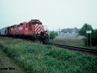 During a hazy and humid summer afternoon, the CP Cobourg Turn is viewed heading back westbound to Toronto, Ontario after completing it’s work at Cobourg. The turn is seen passing the Cobourg station name sign with GP9u’s 8241 and 8206. 