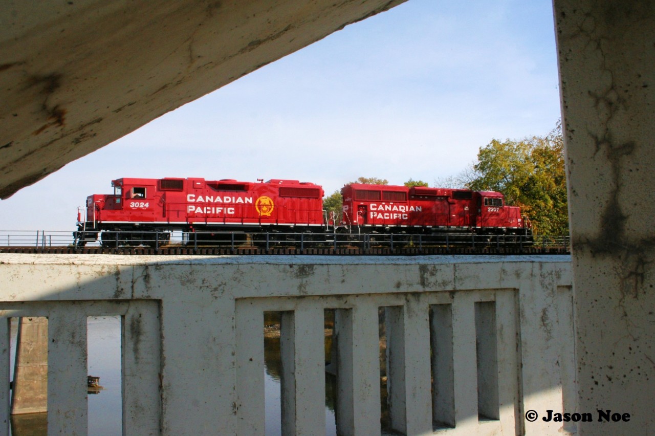 The crew of CPKC H70 have a great view for lunch as they pause over the Grand River in Kitchener, Ontario on the Waterloo Subdivision. The consist included CPKC 3024 and 2207, with GP38-2 3024 having been repainted in a fresh coat of CP red at the AMP facility in Dansville, New York.