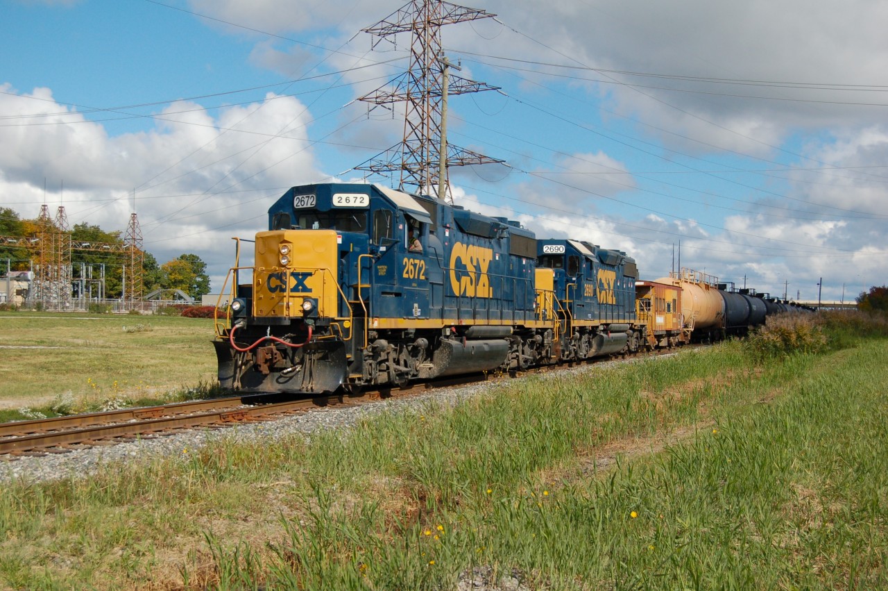 The daily CSX interchange train seen here about to enter the "south" interchange tracks on CSX's Sarnia Subdivision, the power will run around its cars before making the connection to CN's St. Clair River Industrial spur and into CN's large yard at Sarnia, cars are dropped in the CN yard, new ones picked up and return back to CSX rails, this is the only way for CSX to get it's traffic to and from Sarnia as it's Canadian operations are isolated from the rest of the network. Power is locally assigned GP38-2's 2672 and 2690 and ex Chessie caboose 900032. The GP38's and caboose are no longer used in Sarnia.