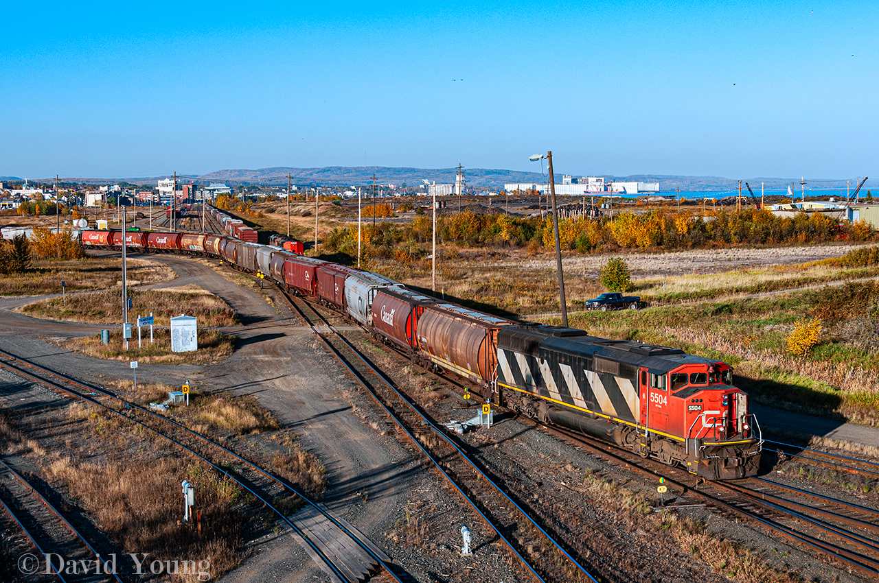 Viewed from the Central Ave overpass, a CN afternoon extra utilizing CN SD60F 5504 shoves a string of grain empties through TC04 and over onto TC92 to be inspected for the evening run of train A437. In the background a pair  SD60F's sit on the Northern Wood lead- named for the large lumber mill that use occupy the lands to the right out of frame. As of 2024, the former Northern Wood and neighbouring property (the old CN ore dock) have been  reorganized into the Midcontinent Terminal. Currently a scrap company ships loaded gons out of the site. More info on the terminal can be found  here.