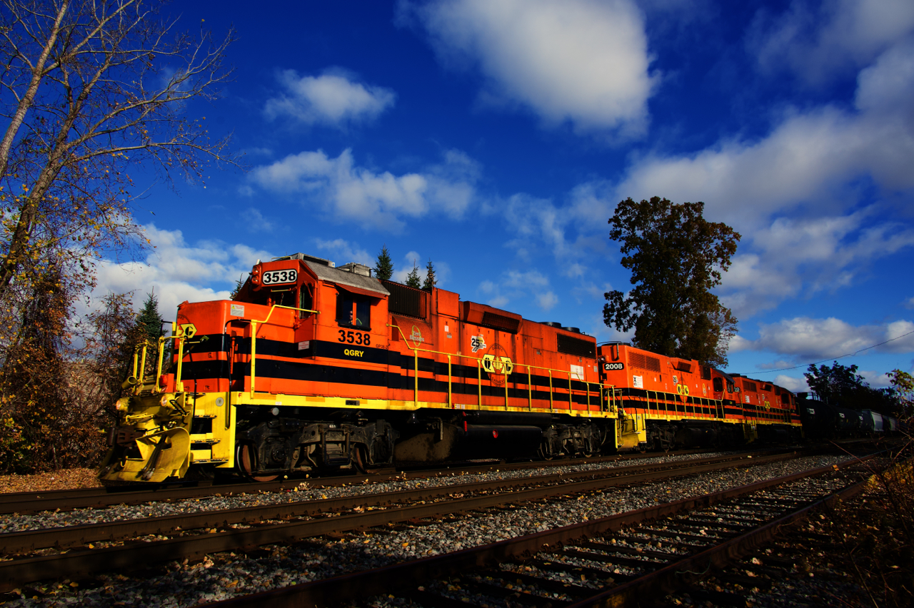 A trio of GP38/GP38-2s leads QG 501 southbound on the Adirondack Sub, on its way to CPKC's St-Luc Yard.