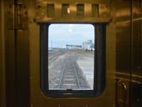 <b> Doo, Doo, Doo, Lookin' out my back door ???? </b> <br>
Prior to VIA 692 The Hudson Bay departing Churchill, MB the evening of September 19, 2024 I snapped this pic through the rear door window and vestibule of VIA 8224 Chateau Roberval sleeping car. <br>
The Churchill grain silos and elevator still stand vacant, waiting a decision on their future use at this deep water port. <br>
The station track has been nicely rehabbed with new ties, new rail, and a lift, level, line and tamp.