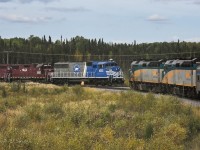 <b> Meeting at the wye </b> <br>The Hudson Bay Railway way freight has just entered the north leg of the wye at Thompson Jct. with VIA 693 The Hudson Bay holding the south leg, waiting it's turn to take the 30 mile trip up HBR's Thompson Sub. to the VIA station at Thompson, MB. <br>A headend crew member from the passenger train does a roll-by inspection of the lengthy freight train, and will then walk several hundred feet to line the switch, allowing VIA 693 to proceed. <br>The way freight consist this day was a very interesting mix of fuel tank cars, general freight boxcars and gons, trucks and construction equipment on flats, and a string of HBRY ballast cars. It was nice to see one of HBRY's newer locomotives on the point. <br>The only thing absent from this photo is a ray of sunshine. :-( <br>A big thank you to my friend Benny for editing this photo.