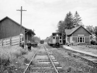 Burlington to Allandale* train 661 makes its stop at Caledon East, exchanging passenger, mail, and express before continuing on their way.  CNR oil-electric 15836 and trailer C1 only have a short time left rattling along the old Hamilton & North Western right of way before this service draws to a close on July 2, 1960.  The Caledon East station, built by the Grand Trunk in 1903, survived until demolition in November 1971.

<br><br>Though undated, spring 1960 can be estimated based on the equipment assigned to 661/662.  Per Charles Cooper's book, <i>Hamilton's Other Railway,</i> oil-electric cars began operating on this run <a href=http://www.trainweb.org/oldtimetrains/photos/cnr_self-propelled/15830.jpg>in 1933 with CNR 15830</a> and a trailer, as seen on numerous branchlines.  This equipment remained until January 1952, when streamlined <A href=http://www.railpictures.ca/?attachment_id=45792>CNR D-1, and trailers C-1 and C-2</a> were assigned to the run.  The unique equipment served the communities along the line until the end of 1958, when D-1 and C-2 were transferred to northern Ontario, with CNR 15832 and trailer C-1 replacing it until a time near the end of service.  As seen above and in other photos by Ian MacDonald (see below), 15836 appears to have been the last oil-electric assigned to the run with trailer C-1.  One constant throughout the years of the oil-electrics was their mechanical issues, resulting in conventional equipment frequently relieving them of their duties, as captured below by Clayton Morgan.

<br><br>*Over the course of its daily except Sunday trip, this equipment carried six train numbers: 660 (Hamilton - Burlington), 661 (Burlington - Allandale), 61 (Allandale - Meaford), 62 (Meaford - Allandale), 662 (Allandale - Burlington), and 663 (Burlington - Hamilton).


<br><br>Scenes from this operation:
<br><a href=https://www.railpictures.ca/?attachment_id=25498>CNR 15836 arriving at Caledon East (Ian MacDonald)</a>
<br><a href=http://www.railpictures.ca/?attachment_id=25499>15836 and C-1 southbound at Stewarttown (Ian MacDonald)</a>
<br><a href=http://www.railpictures.ca/?attachment_id=24668>Conventional equipment at Inglewood (Clayton Morgan)</a>
<br><a href=http://www.railpictures.ca/?attachment_id=45490>CNR D-1 in its later appearance (Al Chione)</a>


<br><br><i>Basil Headford Photo, Jacob Patterson Collection.</i>