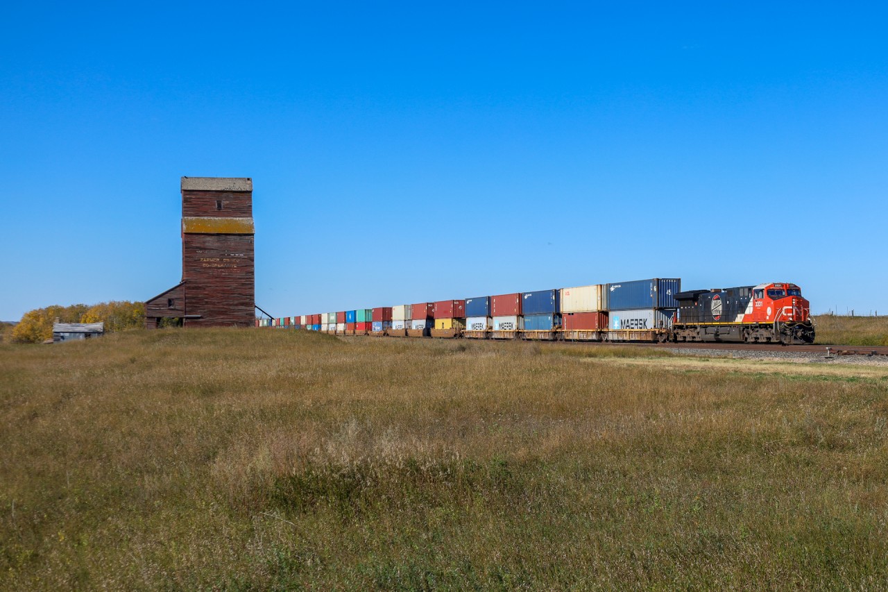 Q 18051 27 cruises past the wooden elevator at Nielsen with CN 3331 featuring a retro CN logo leading.