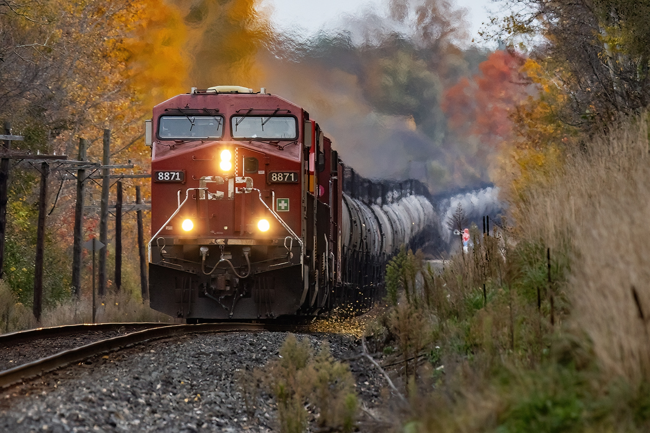 Symmetry. It's why I fell in love with railroading. It started with CN's ore train where I would sit at the station went the family would come into Bracebridge for laundry day. I was lucky enough that my parents would trust 10-year-old me to not get run over while they left to do groceries for a hour or so. I can't remember if Bracebridge still had an operator in those days; I think so but I was too shy to bother them. It graduated to grain trains and a sea or "Trudeau hoppers", all perfectly aligned. Coa; and sulphur trains too. For reasons i can't explain, it doesn't apply to autorack or container trains, but we're all a little eccentric. Which brings us to today; a perfect string of tanks (the idler happily hidden with the power) stepping its way across the Galt Sub as the wind rapidly knocks down too many leaves. Hopefully, the crew was amused as I tried to balance on the roof of my Civic as the wind tried to deposit me back on Mother Earth. While railroading seems to have become a little too ubiquitous...2 GE's and 10000 feet, this is still special.