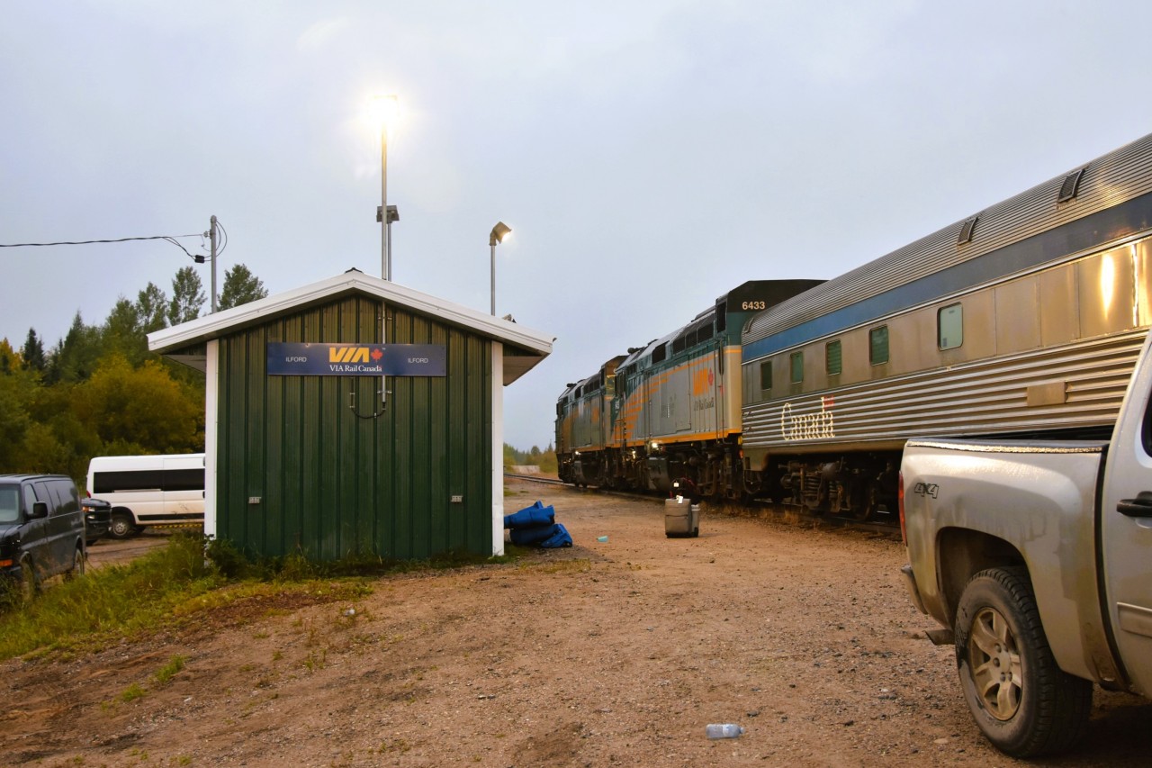 Before sunrise  
Before the sun comes up and turns off the stations photocell lights, VIA 692 The Hudson Bay is making its scheduled stop at the remote northern Manitoba community of Ilford. 
Two passengers to board, a few bags to load, and we'll be on our way south in a few short minutes. Just enough time to grab a few pics in this quaint little village.