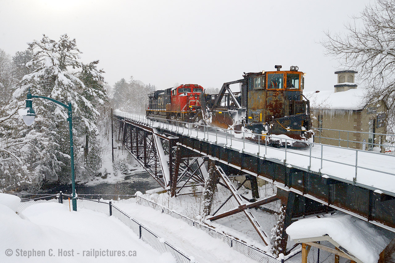 Just off Muskoka Road is a neat little bridge in the town of Bracebridge, and CN spreader "W908" is heading north on the Newmarket Subdivision clearing some of the 3 feet of snow that fell in the days prior. With a sudden and severe cold snap having come in January this meant warmer waters dumped all their moisture as snow over days with local accumulations topping out at 50 cm per day. CN would drag this spreader out of the MOW track in Stratford to bring it to Toronto and run it north on the Bala and Newmarket subs. The building in the background screams cold with large icicles dangling from the roofline. Now owned by the Town of Bracebridge this building was Bird Woolen Mill built in 1918. Source.