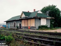 The morning fog has just lifted in the village of South River, Ontario on the CN Newmarket Subdivision. The old CN station, constructed during 1884 by the Northern and Pacific Junction Railway, is viewed sitting boarded-up with the “Save our Station” sign affixed to the one end over its windows. Situated at Mile 188 of the line, the village’s railway history was deemed to important to be lost. In turn the village was able to see that the station was saved, and it was cosmetically restored in later years.
<br>
Presently, work began this spring to prepare it for the resumption of Ontario Northland passenger rail service sometime during 2026. The current Ontario government is following through with a commitment to re-introduce passenger service from Timmins to Toronto and South River is one of the stops. Reportedly, it will be the only scheduled stop between North Bay and Huntsville on the re-introduced ONR passenger service. An article in the North Bay Nugget had said that renovating the former train station back to life again was estimated to cost $414,000.
