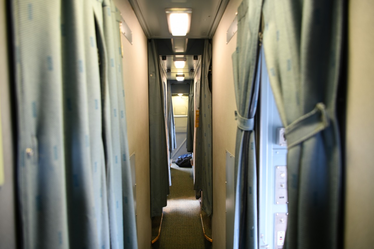 Two-up two-down  
Soiled linen bags lay in the hallway in the roomette end of sleeping car VIA 8224 Chateau Roberval. 
Room attendant Brian has just finished making up the two-up two-down staggered roomettes (cabin for one in VIA lingo) and is now tending to the double bedrooms in the middle of the car. 
With all the 'cabins for two' sold out on this trip, it was my first time in a roomette since the early 1980's. I found the bed more comfortable than in the bedroom for two that I usually occupy, but it was just a little too cramped for those of us that have to get up in the middle of the night (if you know what I mean). ???? Going forward, it's back to a full bedroom for two for me. 
I sure hope these Budd stainless steel sleepers are around for another 10-12 years at least.