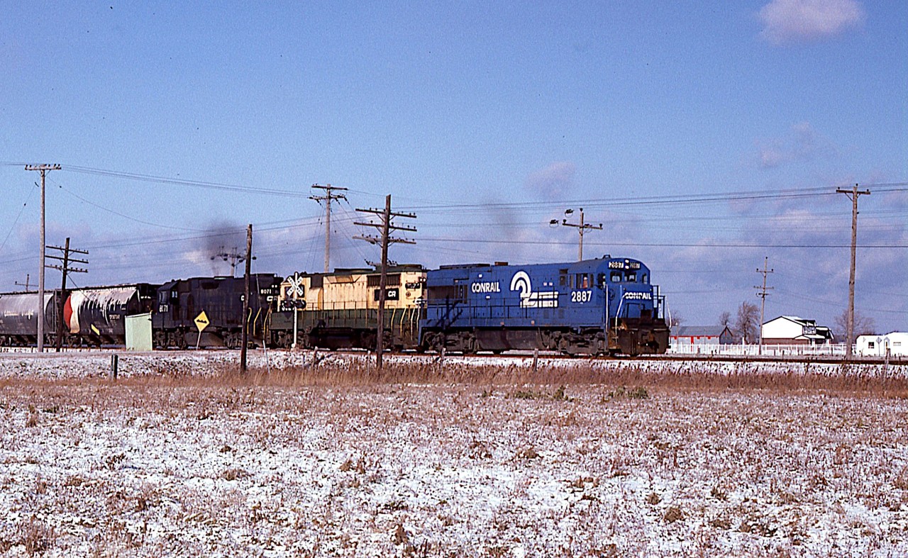 What was a rare catch for me back then was the "CPBU" in daylight. I was a bit of a shock to see this. Like most other fans, I just accepted the fact this generally ran under cover of darkness.
Here it is, Toronto to Buffalo run thru,  moving along at a good clip as it crosses Grimsby Rd (12) as I photographed it from alongside of Young St. The train is close to the Smithville name sign, another quarter mile along.
Power is CR 2887, 3634 (x-RDG) and 8071.