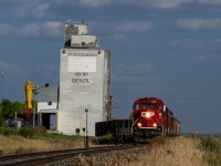 I have been chasing CPR 2212 West from just west of Kerrobert (about 30 miles to the east) as it plodded along the Macklin Subdivision at 10 MPH or so. It has arrived at Denzil where is will lift a few more empty ballast cars. 

