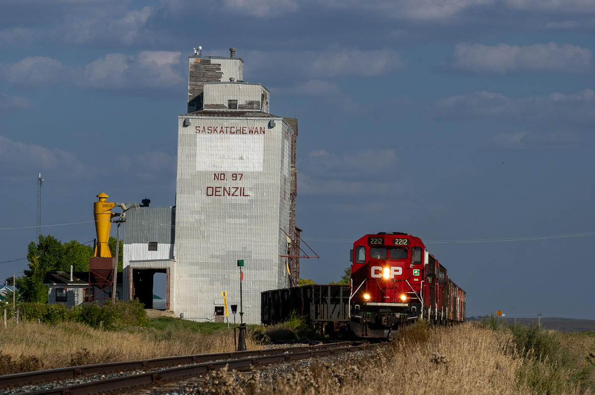 I have been chasing CPR 2212 West from just west of Kerrobert (about 30 miles to the east) as it plodded along the Macklin Subdivision at 10 MPH or so. It has arrived at Denzil where is will lift a few more empty ballast cars.