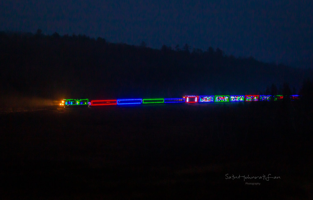 With daylight just beginning, the CPKC holiday train, with a decorated NBSR engine at the point, heads through Clarendon, New Brunswick.