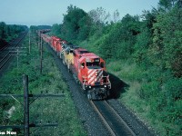 An eastbound CP intermodal train is seen passing through Lobo, Ontario as it approaches the Denfield Road overpass, west of London on the Windsor Subdivision. The consist has a variety of SD40-2’s in various CP paint schemes, including leased GATX SD40-2 903. 