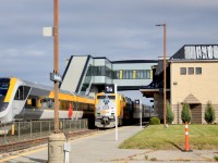 VIA Rail is going West with the old and East with the new. A Halloween afternoon at Belleville Station has VIA Rail Corridor Service train #42 with new Venture Trainset 2213/14 to Ottawa waiting on Track 2. VIA Rail Corridor Service train #53 led by 913, rolls in on track 1 on time. #42 was late by 15 minutes allowing for the meet. The old stone Belleville station in the foreground is overshadowed by the new glass and steel structure in the background.