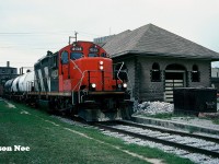 CN GP9RM 4133 leads the 15:30 Kitchener Job through downtown Waterloo, Ontario on the Waterloo Spur as they return from Elmira with two tanks and a caboose. At the time, the Waterloo Grand Trunk station to the right of the train was undergoing an extensive cosmetic restoration. A year later the station received it’s historic building status.