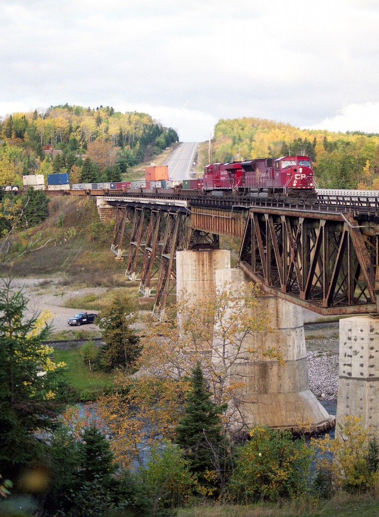 Eastbound CP train #116 with SD90MAC 9111 on the lead is seen crossing the Nipigon River bridge on a late September afternoon in 2007.
Whenever I am around Nipigon I hang around a bit in hopes of catching a train here on account I love the rugged scenery in the area.
I kinda miss the MACs as well, with this one now rebuilt as SD70ACU #7031; I am thinking these rebuilds are just as much of annoyance to the Maintenance Shop as the MACs were.
Second unit is CP 8778. Track down below has now been lifted; it was the old CN Kinghorn Sub.