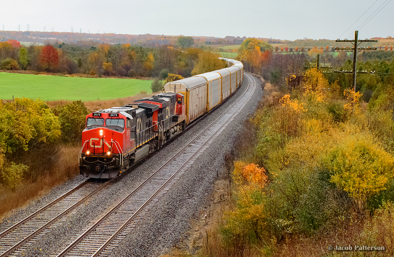 As the rain begins to fall, E271 rounds the curve approaching Newtonville Road, getting back up to speed after slowing for VIA 644 to slip by between a few freights.