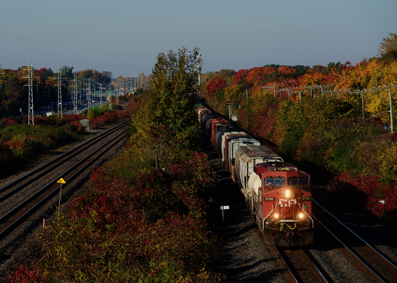 CP 8766 is solo power on a pint-sized CPKC 118 passing fall colours in Beaconsfield.