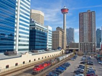 A westbound CPKC grain train is seen stretching out into downtown Calgary as it makes a large double over.