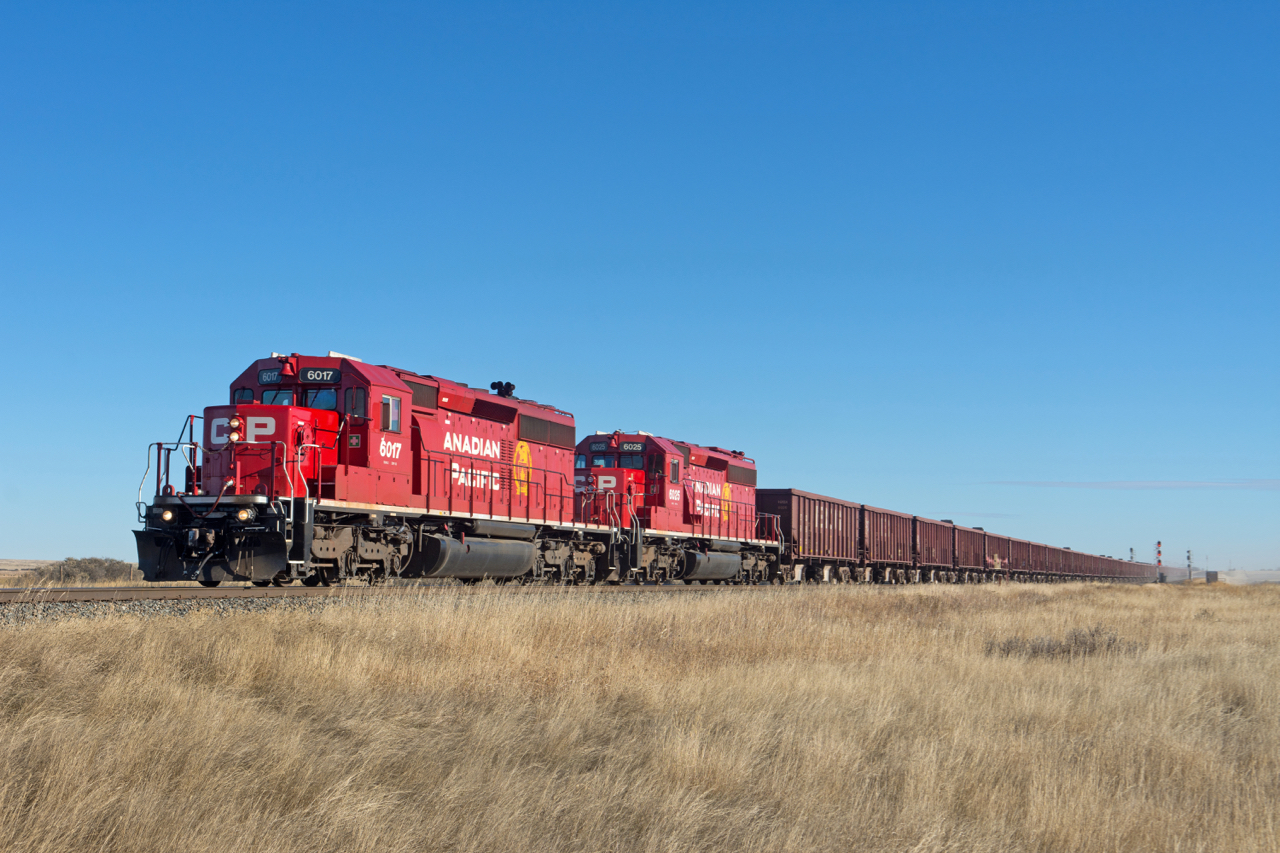 A sharp looking set of recently rebuilt SD40-2s lead a GPS ballast train west along the Swift Current Sub at Rush Lake.