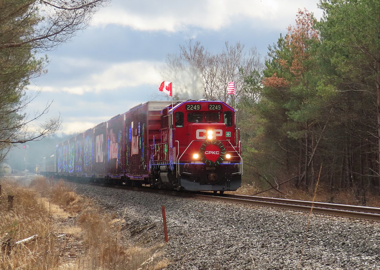 The Holiday Train lays out some exhaust as it accelerates out of Midhurst after a brief stop. A few fans can be seen just to the left of the signal. So far the Barrie area has been spared from the snow, but in another 5 miles the train will be in to it.