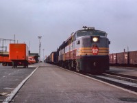 A pair of ALCO 244-powered units built by MLW lead an eastbound freight by Leaside, where a number of Canadian Pacific Express vehicles await their call.

<br><br><i>John Freyseng Photo, Jacob Patterson Collection Slide.</i>