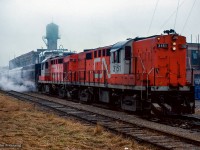 A pair of CN Tempo RS18ms idle away in the rain at Elmira while passengers of the seven car train have alighted to sample the sweet tastes of the Elmira Maple Syrup Festival.

<br><br><i>Scan and editing by Jacob Patterson.</i>