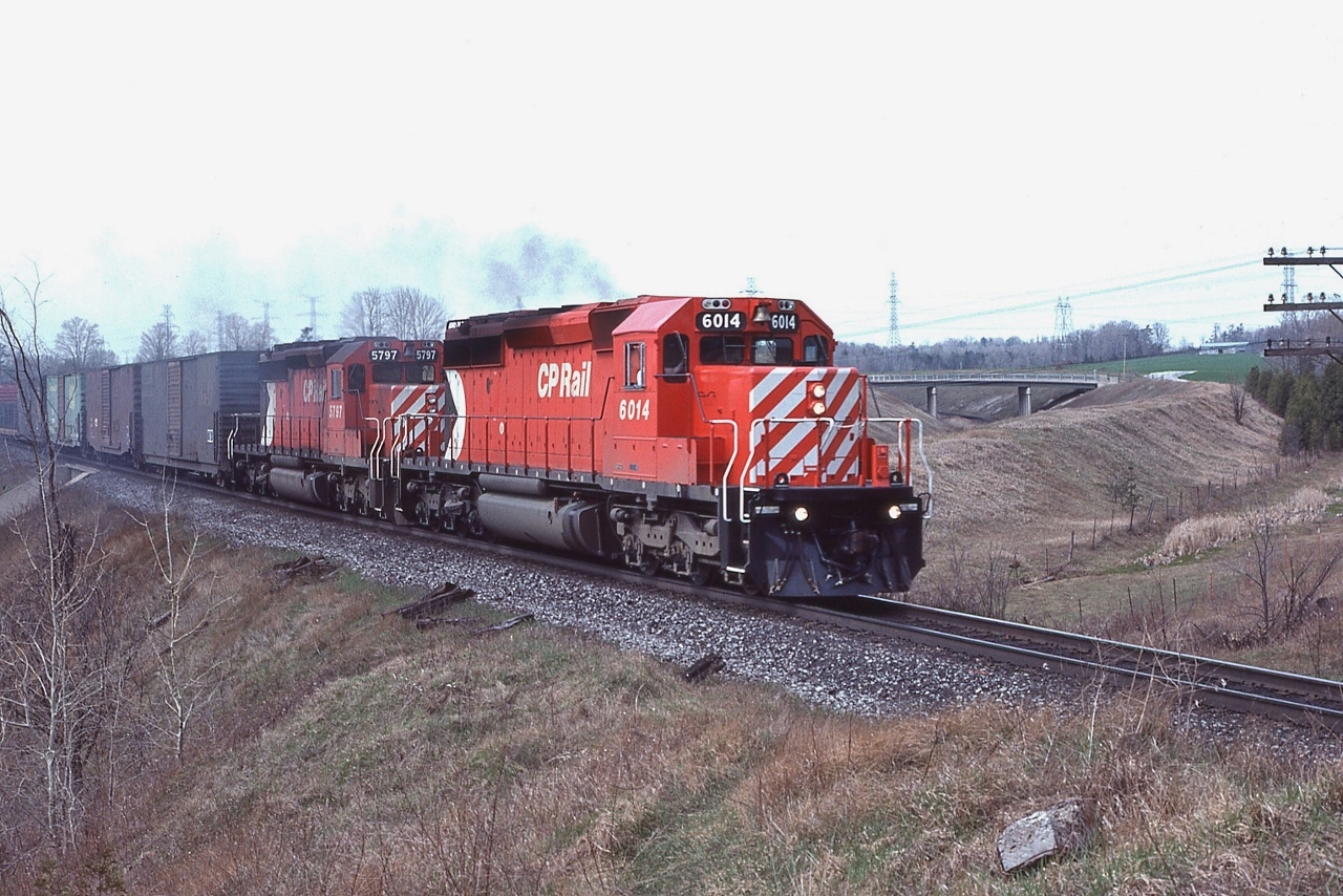 The Rouge Valley and unique place names: Staines, Cherrywood, Locust Hill, CN Beare, and of course Plug Hat Road and Twyn Rivers Drive,


Here a pair of SD's have #916 on the move and on the CN York Sub overpass and about to cross Beare Road on the approach to Cherrywood.


And do note the treeless CN York right-of-way. 


Near mile 191 Belleville Sub-Division with new SD40-2 CP Rail 6014, April 19, 1981 Kodachrome by S. Danko.