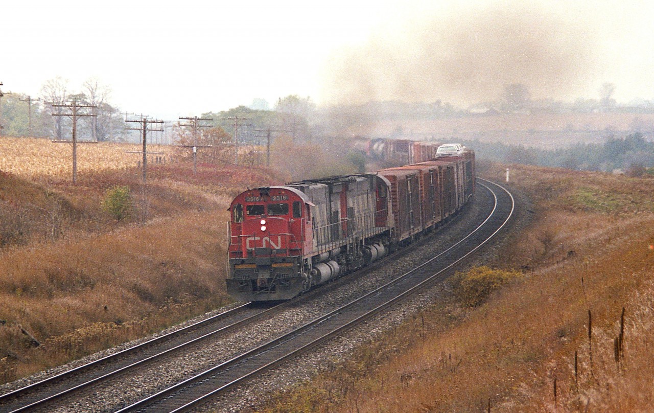 Out at Newtonville for an afternoon's train-watching.  Pity the dull weather, but it was nice to see a few of the old workhorses in action. Here a pair of MLW M-636 locos, 2316 and 2323, create a smoky haze as they power a train eastbound.