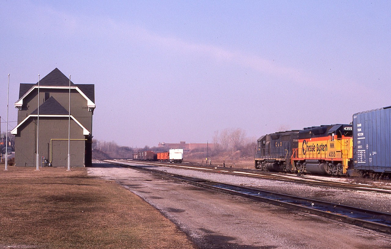 I posted a shot of this train in the CN yard about 6 years ago, but just found this image which is quite nice. In what apparently was a rare move, C&O 3584 and freshly minted WM 4355 are seen just coming into Canada, with the tail end still on the double decked Whirlpool Bridge. This train usually crosses at Fort Erie and I have no concrete idea why it was in Niagara Falls this day. It terminated at the CN yard about a mile along.
On the left is the NF passenger station; it looks like it just went thru a bit of renovation. Flag poles are up, but as yet no flags.
A very quiet looking but nice warm early March morning.