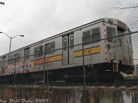 TTC G1 subway car RT-37, one of the last of Toronto's <a href=http://www.railpictures.ca/?attachment_id=43138><b>"Red Rocket" Gloucester subway cars</b></a> still on the property in 2007 (built as TTC 5069 for Toronto's first subway line in 1953-54, retired by the early 90's), sits stored at the back of Greenwood Yard awaiting disposal. At the time, four of the "G's" remained, having been converted after retirement for maintenance of way use as power units for the railgrinder trains that profiled the rails around the subway system during off-peak hours. The sets were made of two G's for propulsion, bookending two small yellow railgrinder units towed in between. A yard collision in 2004 resulted in one set being retired, while the other set remained active until 2008. These were probably the rarest pieces of TTC equipment to photograph at the time, as due to their obscure duties during off-peak hours, they weren't very well known or photographed (it was sheer luck they were parked along the fence and not buried in the yard).<br><br>The story behind the hunt for these cars is somewhat long-winded, so viewers may want to go back to admiring the photo of RT-37 still in existence in 2007. It all started in December 2006, when someone on a discussion board posted a CP24 news article of some Oshawa GO line rider complaining about unsightly graffiti on subway cars parked next to the tracks hurting their eyes every day. Someone pointed out the blurry photo included, taken out of a rainy GO bilevel window, appeared to be some of the old TTC Gloucester work cars, stored on a back track in the subway yard along the railway corridor.<br><br>More intrepid, adventurous photographers were interested, and a plan was hatched by two to go investigate and get photos of the last of the G-series subway cars, conveniently inconveniently parked there. After a meetup at Union Station, hijinks and shenanigans followed with a visit to Bathurst Street bridge for GO, VIA & CN, some streetcar photos at the hip West Queen West & Bathurst, and an escorted visit inside TTC's Russell Yard for some CLRV and vintage PCC streetcar photos. After that, a short walk up Greenwood Ave brought us to the doorstep of TTC's Greenwood subway yard.<br><br>Unlike streetcar yards, one can't just knock on the door of a subway yard and get the red carpet treatment for an escorted tour inside, so scouting outside was the plan. Walking north up the east side of TTC's Greenwood Yard, on the off-chance the G's were visible from the main street, offered no luck. At the north end was Oakvale Avenue, which afforded a <a href=http://www.railpictures.ca/?attachment_id=818>good look south into the yard</b></a>, with lots of T1 and H6 subway cars (but still no G's among them). Then, a detour through the nearby neighbourhood side streets on the west side only yielded high sound barrier walls, with not so much as <a href=http://www.railpictures.ca/?attachment_id=45827><b>a peep possible into the yard</b></a>. Coming out on Jones Avenue, there weren't many options left other than shooting them from the nearby CN rail corridor (if they were still there). Access at Greenwood and Jones Avenues was limited and too conspicuous, but a savvy navigator back then knew lots of the side streets had many "convenient trackside access options" available for the locals walking their dogs and ne'er-do-well crowd engaging in unscrupulous behavior and the like (this was before the Metrolinx days of tall fences everywhere, which was no doubt big business for some lucky fence contractors).<br><br>Sure enough, a dead-end street nearby offered a short dog walk option to the back of Greenwood Yard, with two TTC G-cars parked along the fence immediately visible for all to see: TTC G1 RT-37 (ex-5069) and G2 RT-34 (ex-5102). At the time, there were two steel (former red, now painted maintenance grey) G1's left on the property, and two aluminum (unpainted, but weathered grey) G2's, all sporting yellow maintenance striping.  RT-34 had been involved in a sideswipe incident with a T1 in 2004, and was retired & parked with a visibly damaged cab. RT-37, presumably its mate in the set, was parked out of service with it, both on a disused dual-gauge track at the back of the yard that was formerly the <a href=http://www.railpictures.ca/?attachment_id=30975><b>CN siding leading into the property</b></a>.<br><br>Despite the fence, photos were had, including the heavily rebuilt RT-11 "Duncan's Dragon" tunnel clearance car stored on the same track. Nearby was the other railgrinder set (still in use at the time) with G1 RT-36 (ex-5068) and G2 RT-35 (ex-5103) parked by the heating building at the south-west end, but people working nearby and poor photo angles discouraged getting too close. Satiated with photos, a short walk back to Jones Avenue and a ride on the Jones bus lead us back to the Bloor-Danforth subway, and after a bit of <a href=http://www.railpictures.ca/?attachment_id=34662>H4 subway riding</b></a> it was decided to call it a day, with the mission complete and all main objectives achieved.<br><br>The four G-series RT work cars all went for scrap over the next two years, and that was that for the Gloucester fleet in Toronto (two other G1's, 5098 & 5099, were donated for preservation to the HCRY after retirement in 1991).