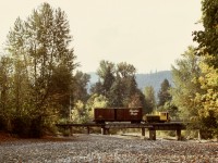 On Vancouver Island between a CP interchange at Lake Cowichan and a sawmill at Honeymoon Bay, Western Forest Industries operated a six-wheel Plymouth WLG3 (serial 3365 built 1929-11) numbered 40 (previously 7), and on Tuesday 1973-10-02, it picked up one empty boxcar from the interchange, seen here westward crossing over the Robertson River with three miles to go to reach home base.

<p>Remarkably, that locomotive survives today at ninety-five years old, after serving for Westcan Terminals at Ogden Point in Victoria, now on display at the Kaatza Museum in Lake Cowichan, only three and one-half miles east of this photo location.