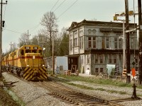 From New Westminster, BC Hydro ran a daily Valley Freight to the U. S. A. border interchanges at Huntingdon, regularly using three (and occasionally four) of their SD38s for power.  On Monday 1977-04-18, SD38-2 units 382 + 383 + 384 were in command, shown here passing the former BC Electric Railway substation at Coghlan just before crossing 256th Street.