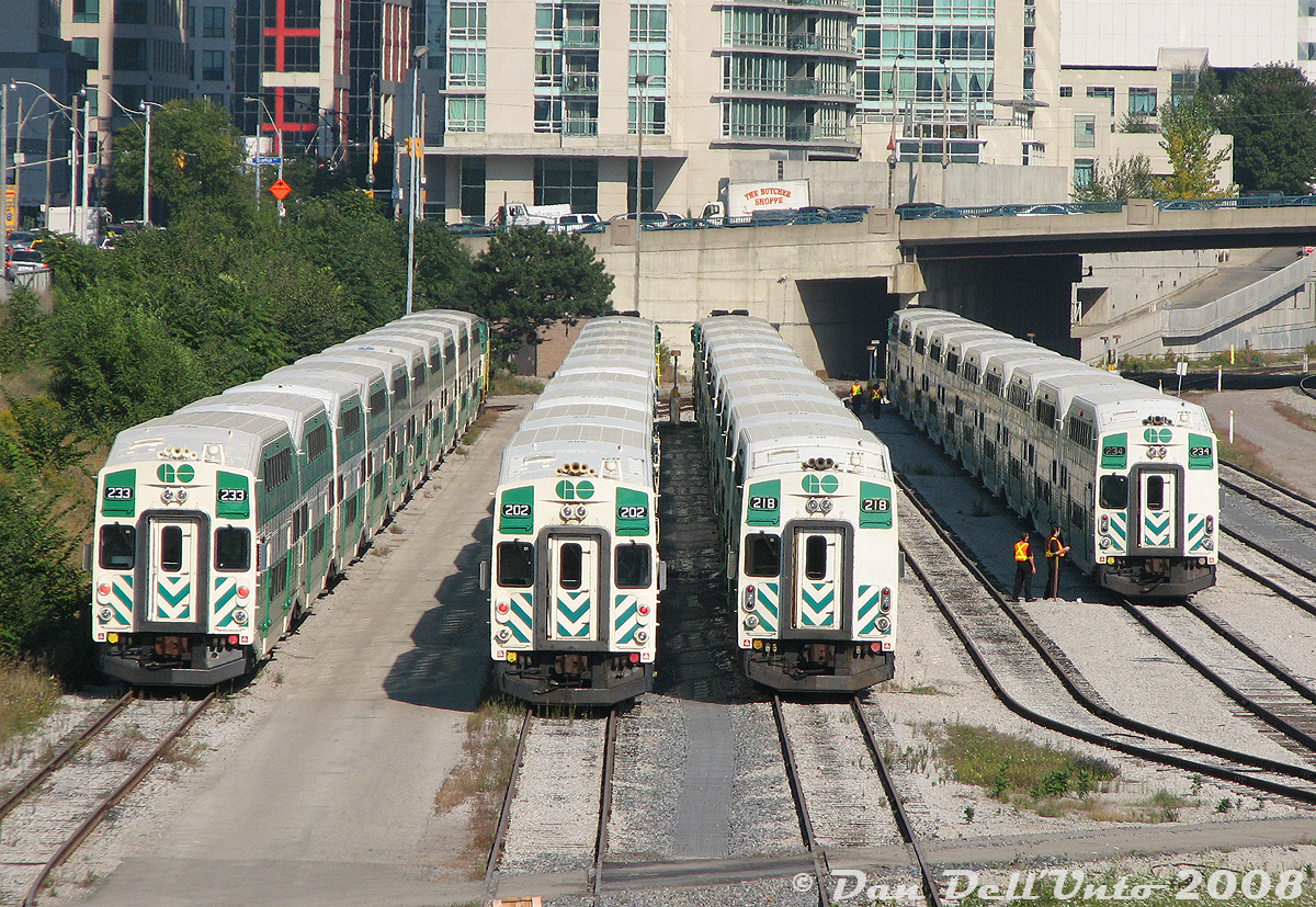 GO Transit cab cars 233, 202, 218 and 234 sit with their trainsets at GO's Bathurst North Yard in the late afternoon, as viewed from Bathurst Street bridge. They will soon be called to nearby Toronto Union Station for PM rush hour duties (the crew of 234 appears to be getting their set ready to depart soon).

At the time, the first group of cab cars (200-214) had already been rebuilt and equipped with a full-width cab (note the 2 front windows), and the second and third groups (215-223, 224-241) were undergoing rebuild, hence 233 freshly rebuilt, and 218 and 234 still waiting to lose their "ogre eye" single window look.