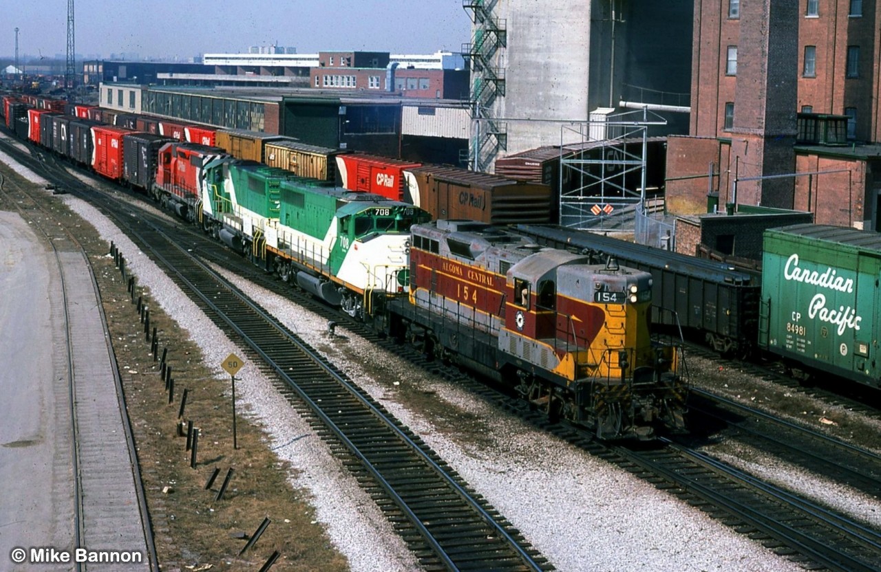 What might be the most unusual power set I have ever seen in Ontario.
Power short CP had borrowed GO units and had leased Algoma Central #154 on a transfer from Lambton yard to Agincourt.
Vantage point is the long gone Weston Road bridge over the diamonds