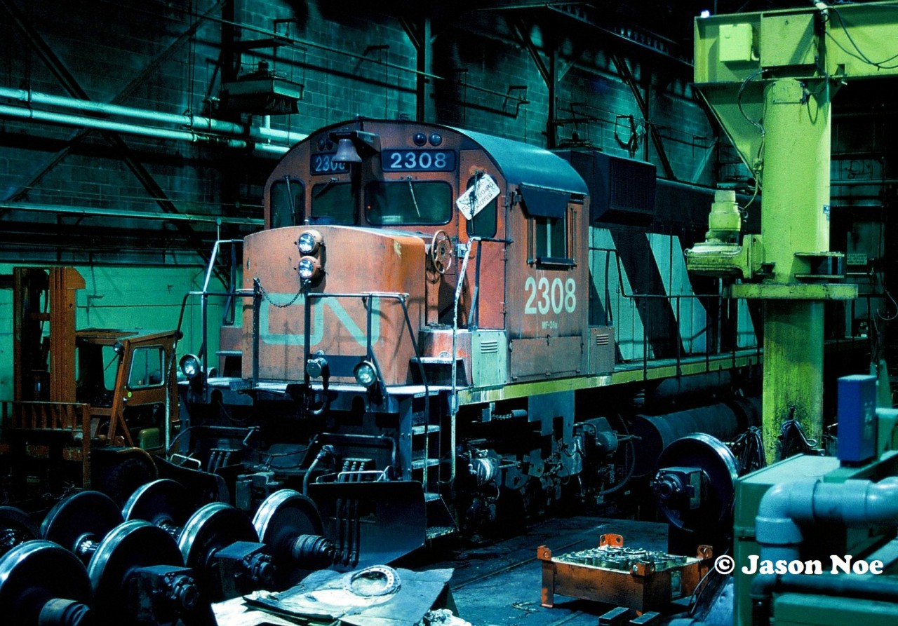 In late 1994, as the season changed from fall to winter, CN’s big MLW fleet was still hanging on, however their active numbers were slowly dwindling down. 

Here, CN M-636 2308 is viewed inside one of the service bays at MacMillan Yard in Vaughan, Ontario. The unit was officially retired by CN on May 23, 1995 and eventually scrapped in New Brunswick after having parts removed at Gordan Yard in Moncton.