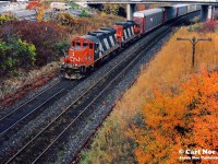 Carl Noe’s trusty plumbing van looks on as CN GP9RM’s 4128 and 4143 power a westbound local approaching Bayview Jct. in Burlington, Ontario on the Oakville Subdivision. 