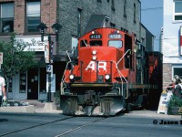 -rp.ca #1000 
<br>
A year after being applied, the AR Illinois graphic still looks fresh as 4138 leads the CN 15:30 Kitchener Job to Elmira on the Waterloo Spur, about to cross King Street in downtown Waterloo. This was the first time I had photographed 4138 on the line heading north since my cab ride three years prior. The mid-90’s was a simpler time in Uptown Waterloo, back during an era when CN trains to Elmira operated almost un-noticed in daylight. Except for those few devoted local fans that would regularly photograph them. 
